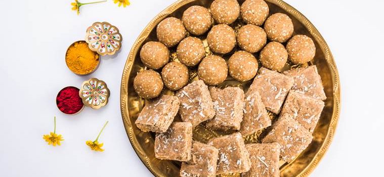 Huldi or turmeric and kumkum or kum kum with tilgul laddu or laddoo in silver bowl, sweet dish in Makar Sankranti festival in hindu religion in India, Indian sweet, isolated on white background